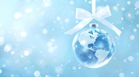Glass Christmas ball ornament with Earth globe inside on light blue snowy background with white ribbon bow, winter holiday decoration for global celebration.