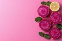 Fresh sliced dragon fruit and lemon arranged with mint leaves on pink background, flat lay composition with copy space for healthy eating concept.