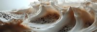 Flowing liquid chocolate and milk creating dynamic splash patterns with smooth creamy textures and rich brown tones for culinary and beverage advertising.