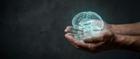 Male hands holding glowing digital brain hologram against dark background representing artificial intelligence, neuroscience and mental health concepts.
