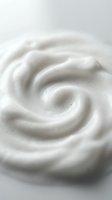 Creamy white swirl texture with smooth flowing curves and soft highlights creating elegant spiral pattern for skincare and beauty applications.
