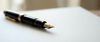 Elegant black fountain pen with gold nib resting on clean white paper surface, perfect for writing, signing documents, and professional correspondence.