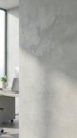 Modern minimalist office interior with concrete wall texture and natural window light creating soft shadows for contemporary workspace design.