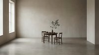 Minimalist dining room interior with wooden table, two chairs, and potted plant in bright natural light from window.