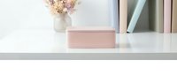 Minimalist pink jewelry box on white surface with dried flowers and books creating elegant feminine workspace decor for luxury storage and organization.