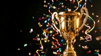 Golden trophy cup with colorful confetti and streamers celebrating victory, achievement and success on dark background for awards ceremony.