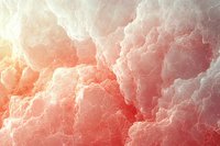 Ethereal coral pink clouds with golden sunlight creating dreamy atmospheric background. Soft fluffy cloudscape texture for spiritual and heavenly designs.