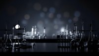Laboratory glassware and equipment on dark surface with dramatic lighting and bokeh background for scientific research and chemistry concepts.