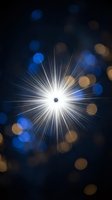 Bright star burst with radiant light rays and colorful bokeh circles on dark background for festive designs and cosmic themes.