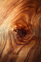 Natural wood grain texture with prominent knot pattern in warm brown tones for interior design and carpentry projects.