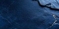 Dark blue slate stone texture with rough surface and natural cracks creates dramatic background for luxury product presentation or website header design.