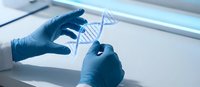 Scientist in blue gloves examining DNA double helix model in modern laboratory for genetic research and biotechnology studies.