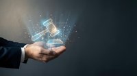 Businessman hand holding glowing digital gavel with sparkles representing legal technology, justice system innovation and law firm digital transformation.