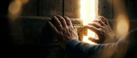 Hands reaching toward warm golden light streaming through wooden door opening, symbolizing hope, opportunity, freedom and spiritual awakening concept.