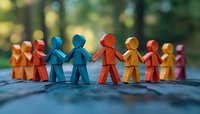 Colorful paper chain people holding hands in unity against blurred natural background, symbolizing diversity, teamwork and community connection.