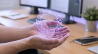 Hands holding glowing digital globe with network connections in office workspace, representing global communication, technology innovation, and international business connectivity.