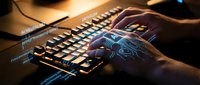 Hands typing on illuminated gaming keyboard with blue LED backlighting in dark environment. Professional workspace setup for coding, programming, and computer work.