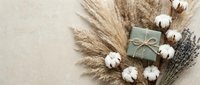 Elegant natural gift box with dried pampas grass, cotton flowers and lavender on neutral beige background for eco-friendly packaging and sustainable design.