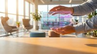Businessman holding holographic digital interface with analytics charts and data visualization in modern office workspace with natural light.