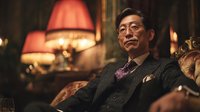 Sophisticated Asian businessman in elegant suit relaxing in luxurious vintage interior with warm lighting for corporate lifestyle and success concepts.