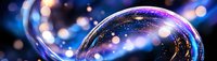 Transparent soap bubble with cosmic galaxy effect against blurred blue bokeh background, creating magical atmosphere.
