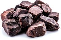 Roughly chopped dark chocolate chunks with uneven surfaces and rich brown color on white background, isolated for confectionery and baking designs.