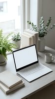 Laptop with blank screen on wooden desk near window with potted plants, books, and coffee mug for workspace design and remote work concepts.