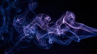 Abstract purple and blue smoke swirls on black background creating ethereal flowing patterns for modern design projects and artistic compositions.