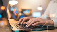 Professional hands typing on laptop keyboard with digital network connections and glowing data streams in modern office environment with bokeh lights.