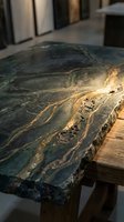 Luxury green marble countertop with golden veining on wooden base in modern kitchen interior design for upscale home renovation projects.