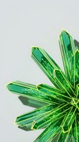 Green crystal formation with geometric faceted structure casting shadows on neutral background for luxury jewelry and gemstone design concepts.