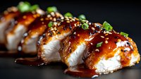 Grilled chicken breast slices with teriyaki glaze and sesame seeds garnished with fresh herbs on dark background for restaurant menu and cooking content.