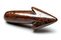 Ancient iron arrowhead with rust and patina showing archaeological details and historical weapon craftsmanship against white background.