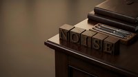 Vintage wooden letterpress blocks spelling NOISE on printing press table with warm lighting creating nostalgic typography atmosphere for creative projects.