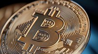 Golden bitcoin macro shot showing detailed cryptocurrency coin texture and surface with metallic shine against dark background. Digital money concept.