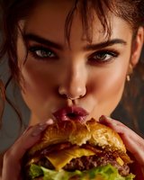 Close-up portrait of a young woman with intense gaze taking a bite of a juicy cheeseburger, showcasing indulgent food enjoyment.