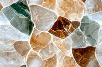 Natural stone mosaic pattern in brown, green and white colors with translucent crystal texture and backlit effect creates abstract geometric background.