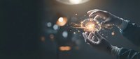 Hands holding glowing light bulb with sparkling energy, representing innovation, creativity, and bright ideas for business solutions and entrepreneurship.