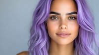 Young woman with vibrant purple hair and natural makeup looking at camera with confident expression for beauty and fashion content.
