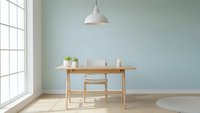 Modern minimalist home office with wooden desk, pendant lamp and sage green wall. Clean Scandinavian interior design for remote work and productivity.