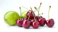 Fresh ripe red cherries and green lime on white background, healthy organic fruits with water drops, raw natural produce for cooking and desserts.