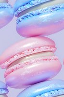 Pastel pink and blue macarons with iridescent shimmer effect and delicate filling create dreamy dessert composition on light background.