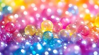 Colorful water beads in rainbow colors with soft bokeh effect creating magical abstract background with pink, blue, yellow and purple translucent spheres.