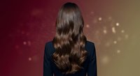 Professional businesswoman with long wavy brown hair from behind against gradient background with bokeh lights for corporate and beauty concepts.