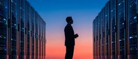 IT professional silhouette standing between server racks in modern data center during sunset with glowing blue lights for technology concepts.