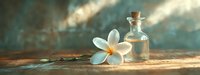 White plumeria flower and glass bottle with essential oil on rustic wooden surface against blurred turquoise background in soft natural light.
