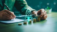 Businessman analyzing financial data with digital home investment icons and coin stacks on desk representing real estate planning and wealth management.