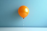 Single orange balloon floating against light blue wall and white surface, creating minimalist composition with soft shadows and reflective highlights.