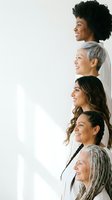 Five diverse women of different ages and ethnicities standing in profile formation smiling confidently representing unity, empowerment and generational diversity.