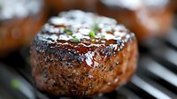 Juicy grilled beef tenderloin steak with pepper crust and caramelized glaze on dark background, macro shot showing texture and seasoning details.